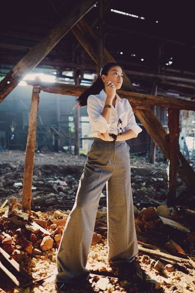 A young woman poses in brown slacks