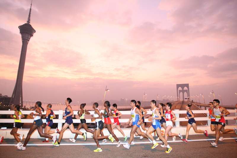 Runners running over bridge in Macau marathon