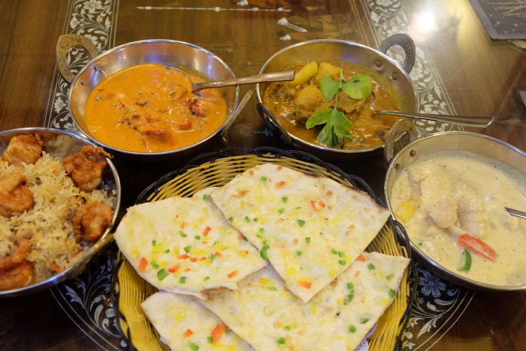 Various Indian dishes laid out on table at India Garden restaurant in Macau.