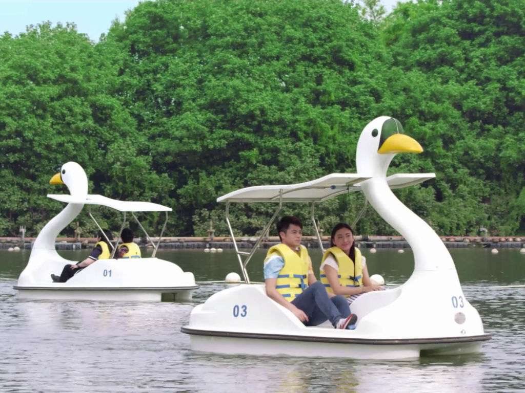 Four people on paddle boats on Nam Van lake. 