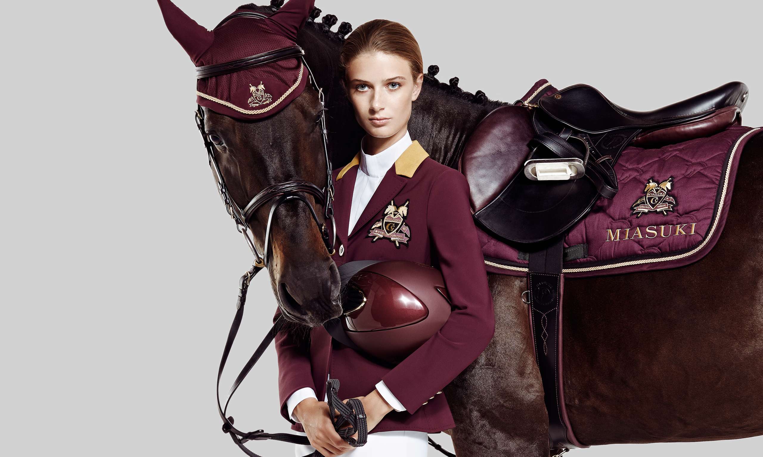 Female model in equistrian clothes and horse