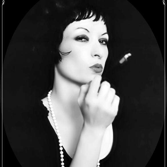 Ines Trickovic holding cigarette holder in classy black and white portrait.
