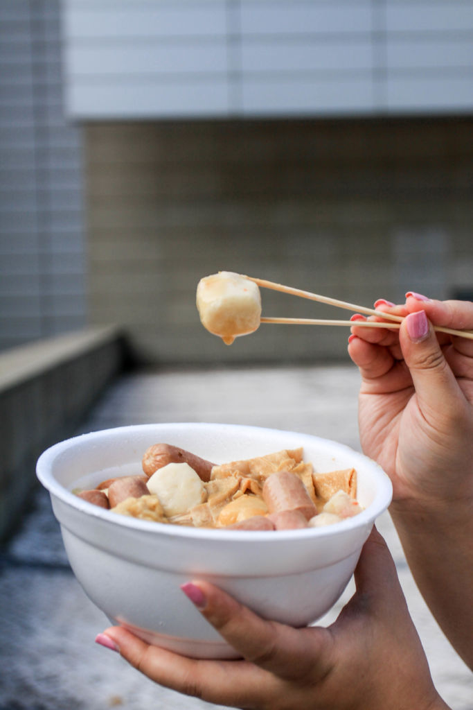 Holding up a fishball.