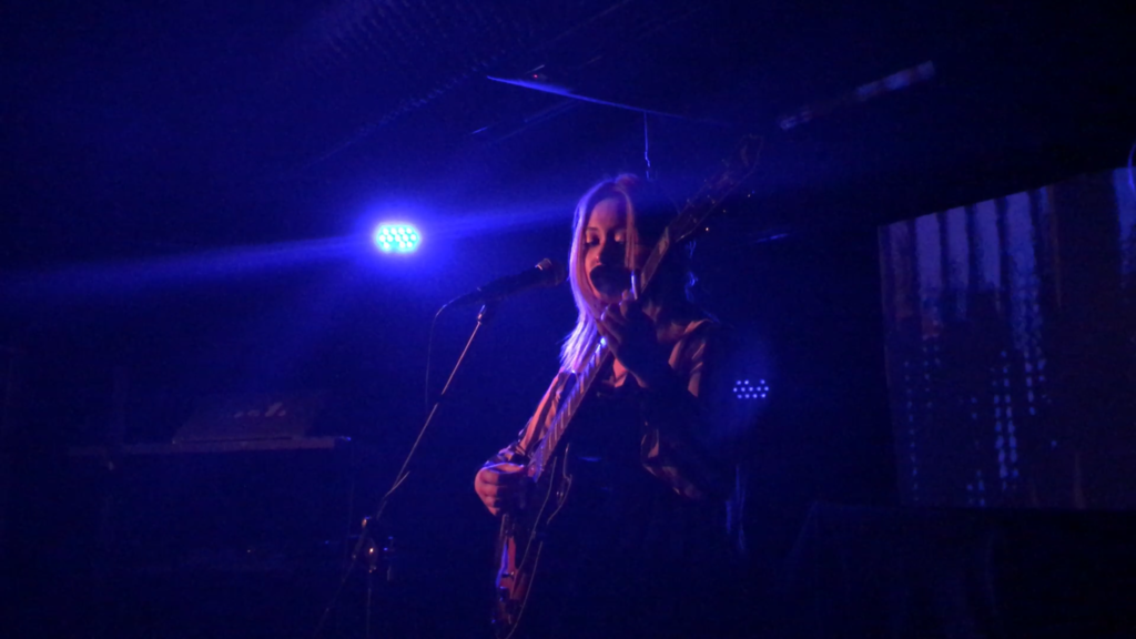 Artist Amanda Chan performing with her guitar