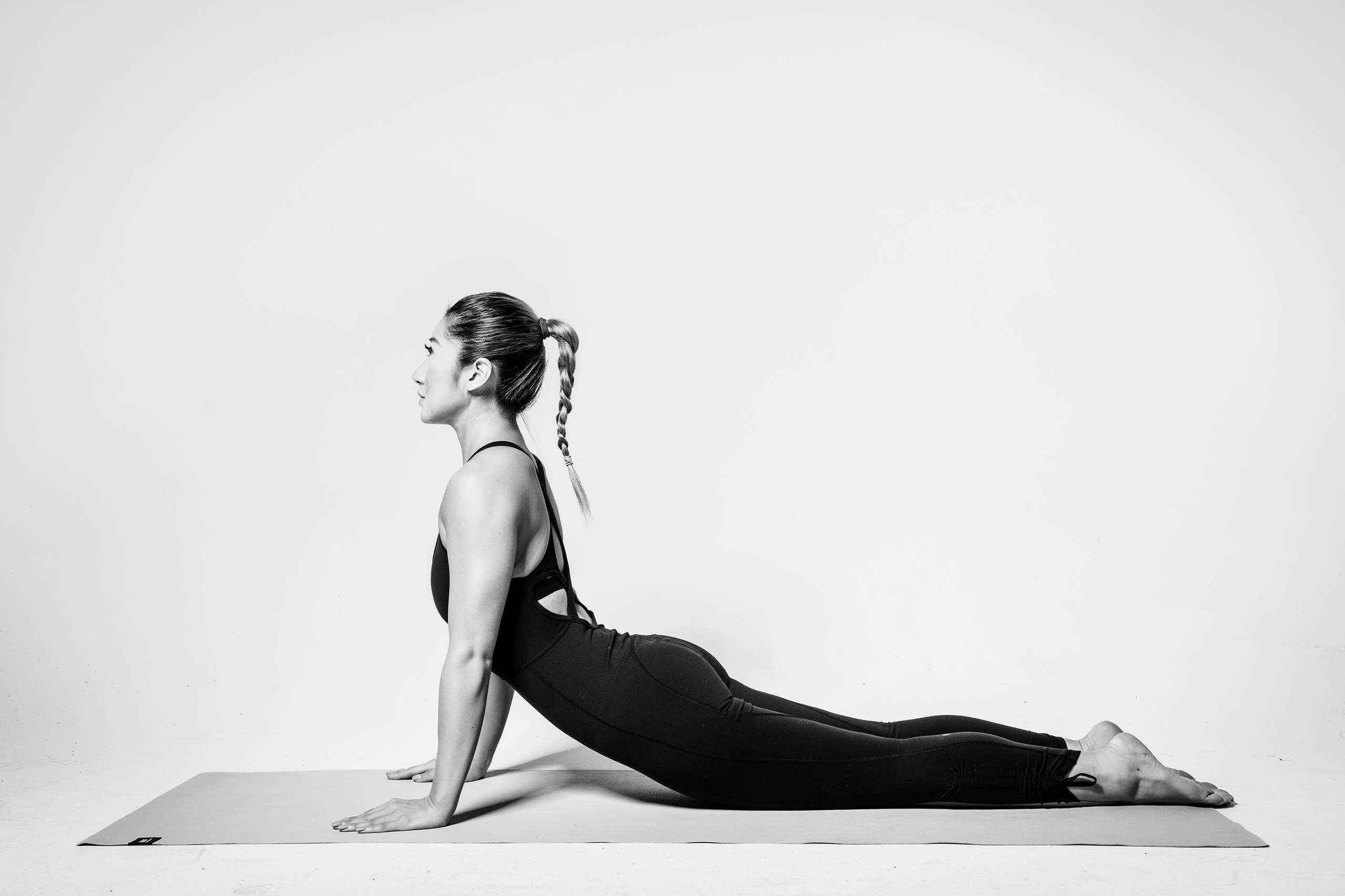 Ceci Lam pilates pose on a mat black and white