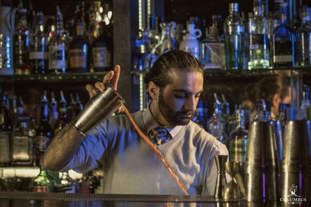 Mixologist Luca Cinalli pouring drink from cocktail shaker. 