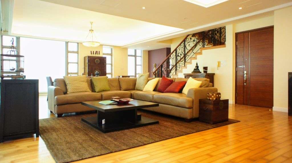 Living room with grey couch and staircase going up buying property macau