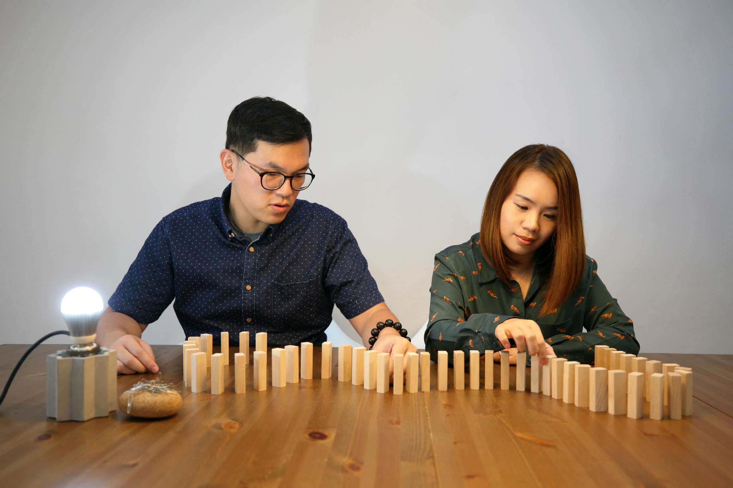 Nomad Design Macau Stanley and Sadie moving wooden blocks around a table and thinking about a design project.