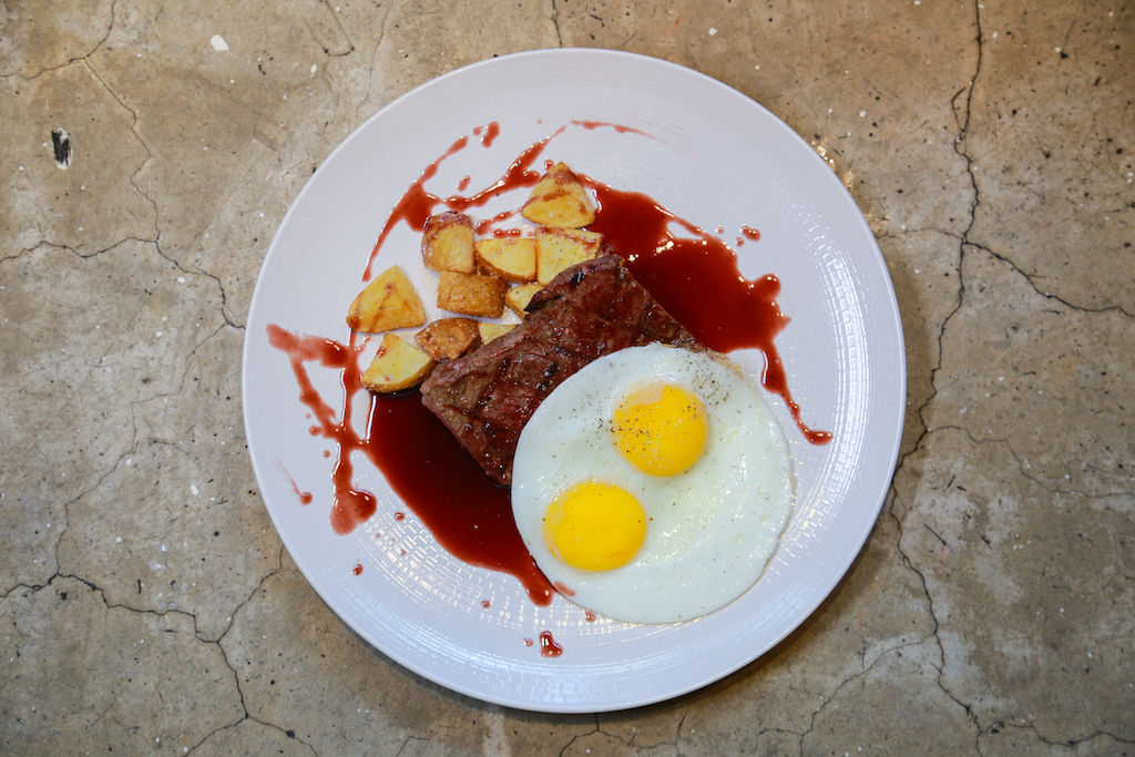 A breakfast plate of eggs, steak, and potatos
