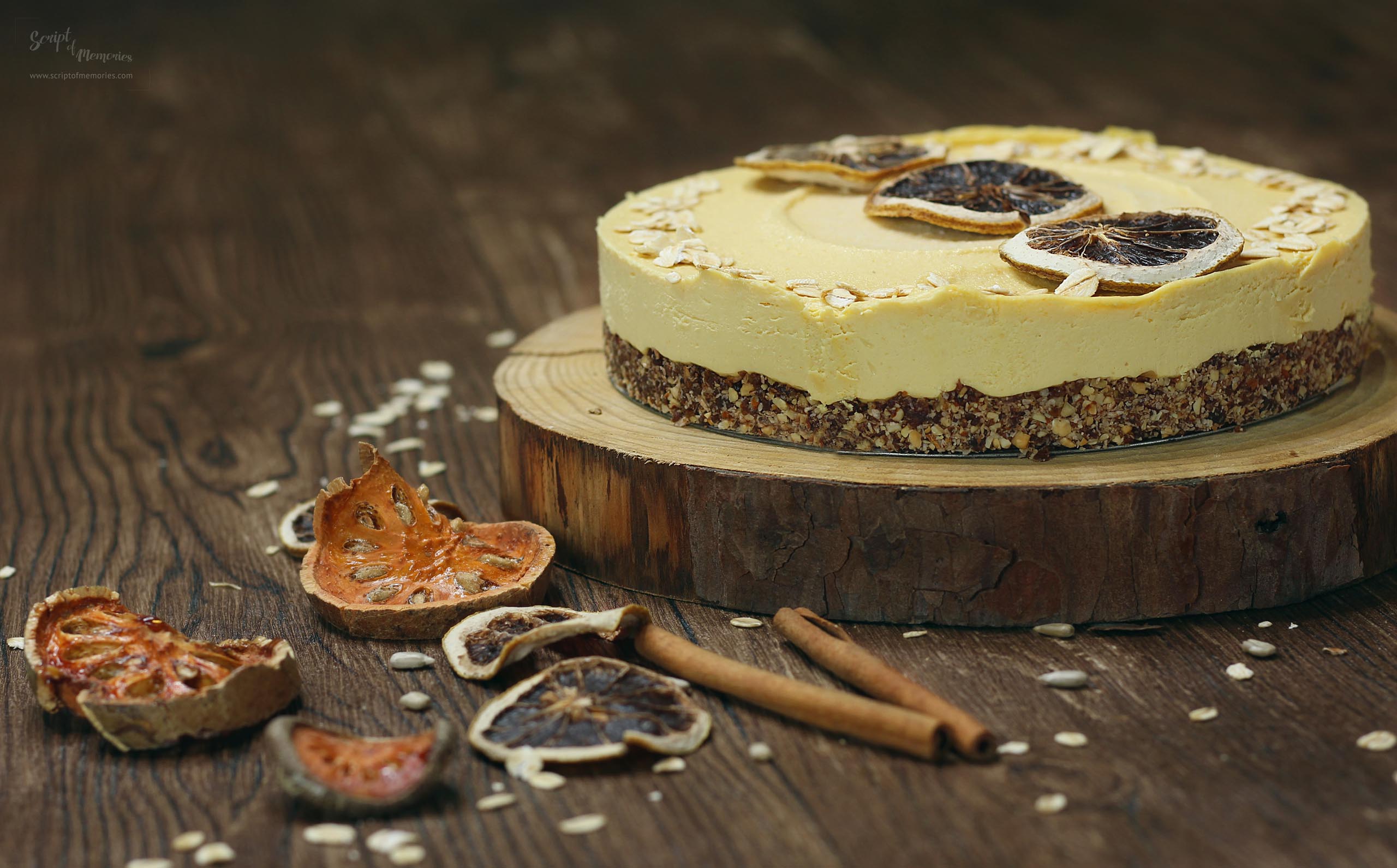 A yellow colored raw cake with dried fruit slices. 