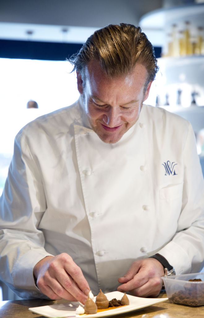 Chef Michael White plating a dish in the kitchen
