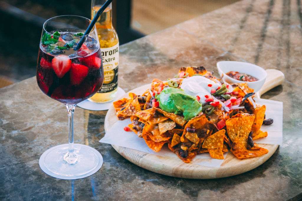 Sangria, beer, and a nacho snack dish. 