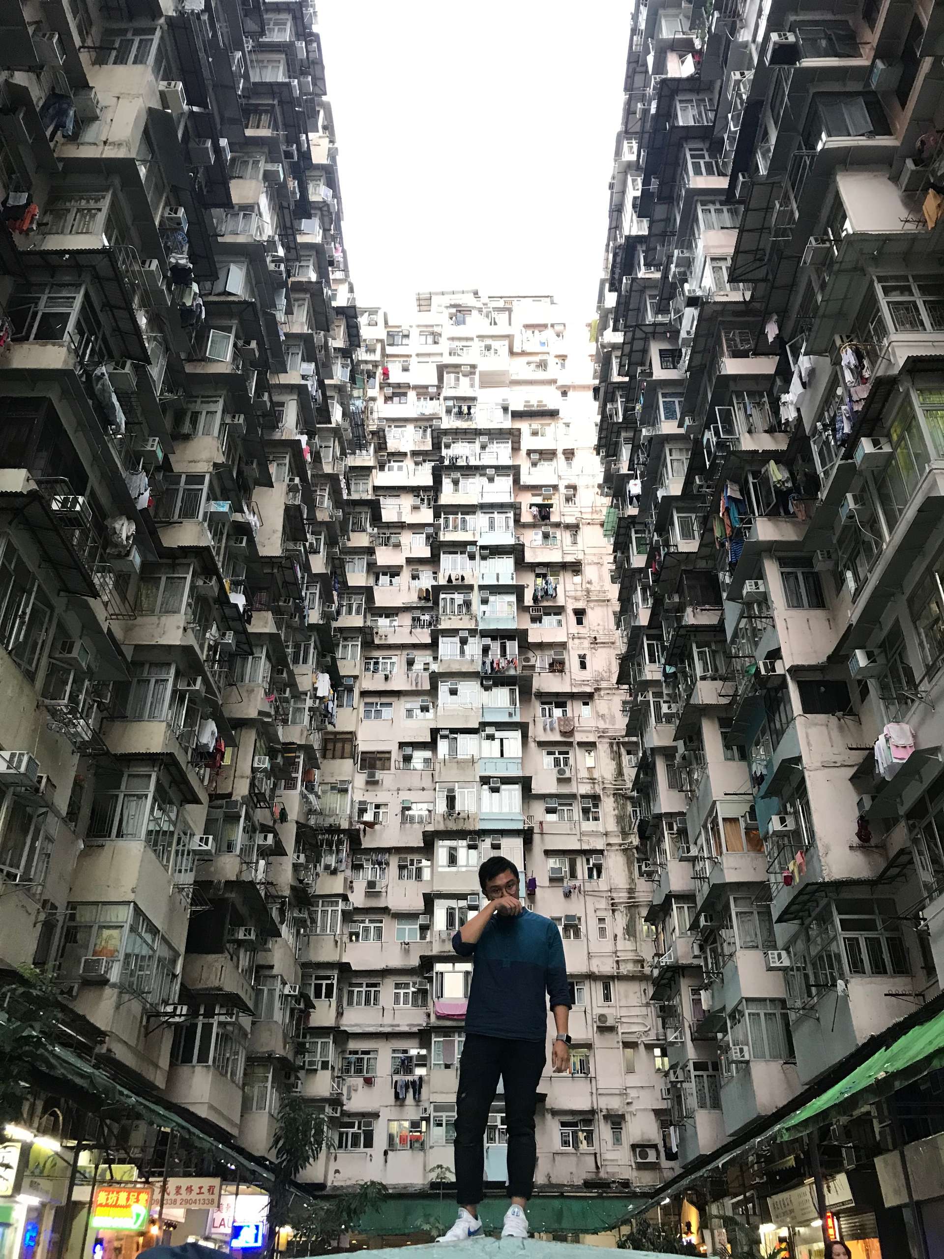 A young man posing with high residential blocks in background in Macau. 