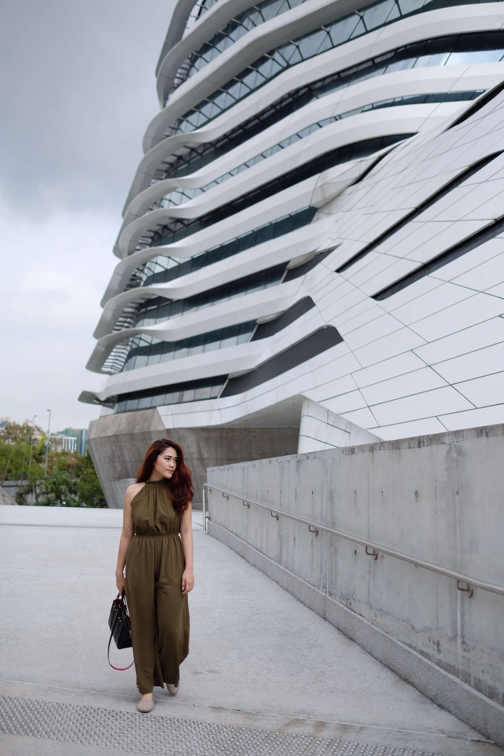 A young woman wearing a brown one piece walks on street in Macau