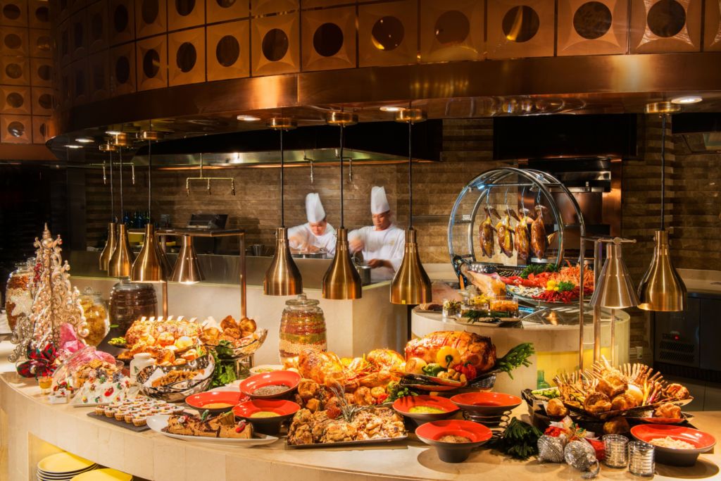 Two chefs working at a buffet. 