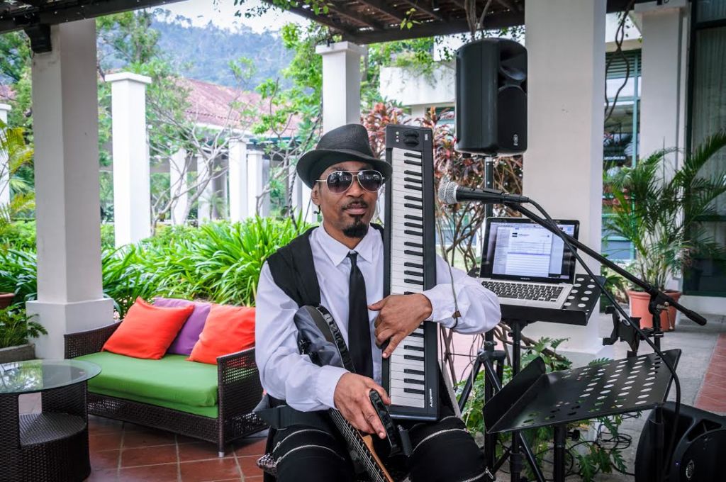 Man wearing sunglasses and holding a keyboard