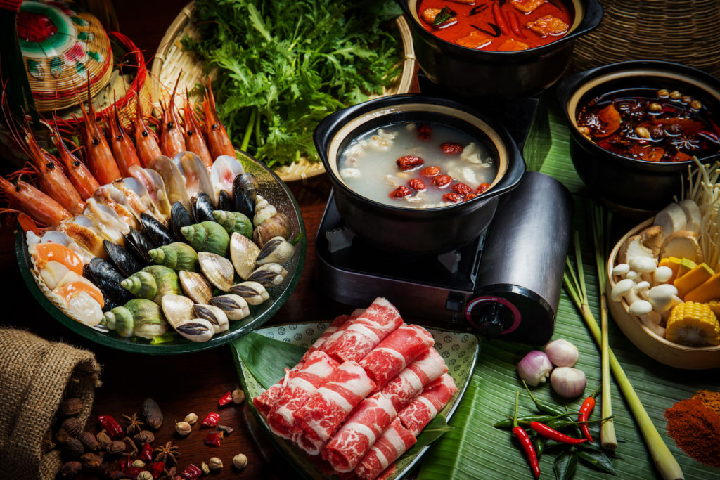 Various meats, vegetables, and seafoods assembled for a hotpot.