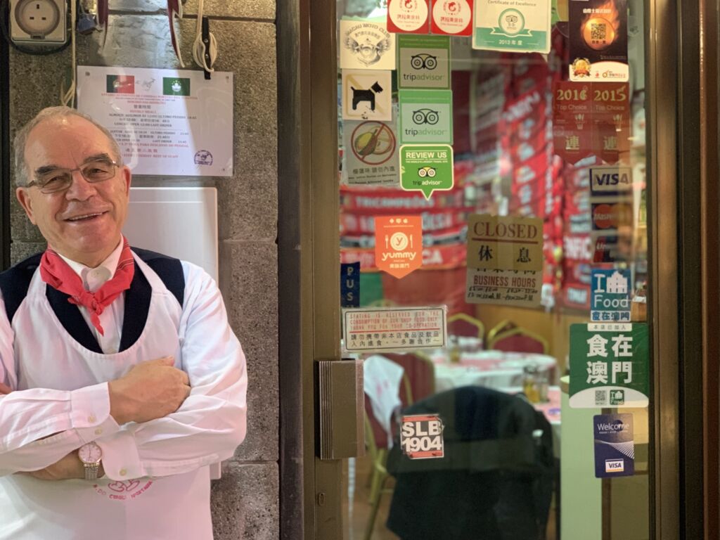 Santos standing in front of O Santos Comida Portiguesa restaurant