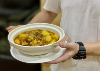 Julio Lei holding a pot of ox tail curry from APOMAC Macau Lifestyle