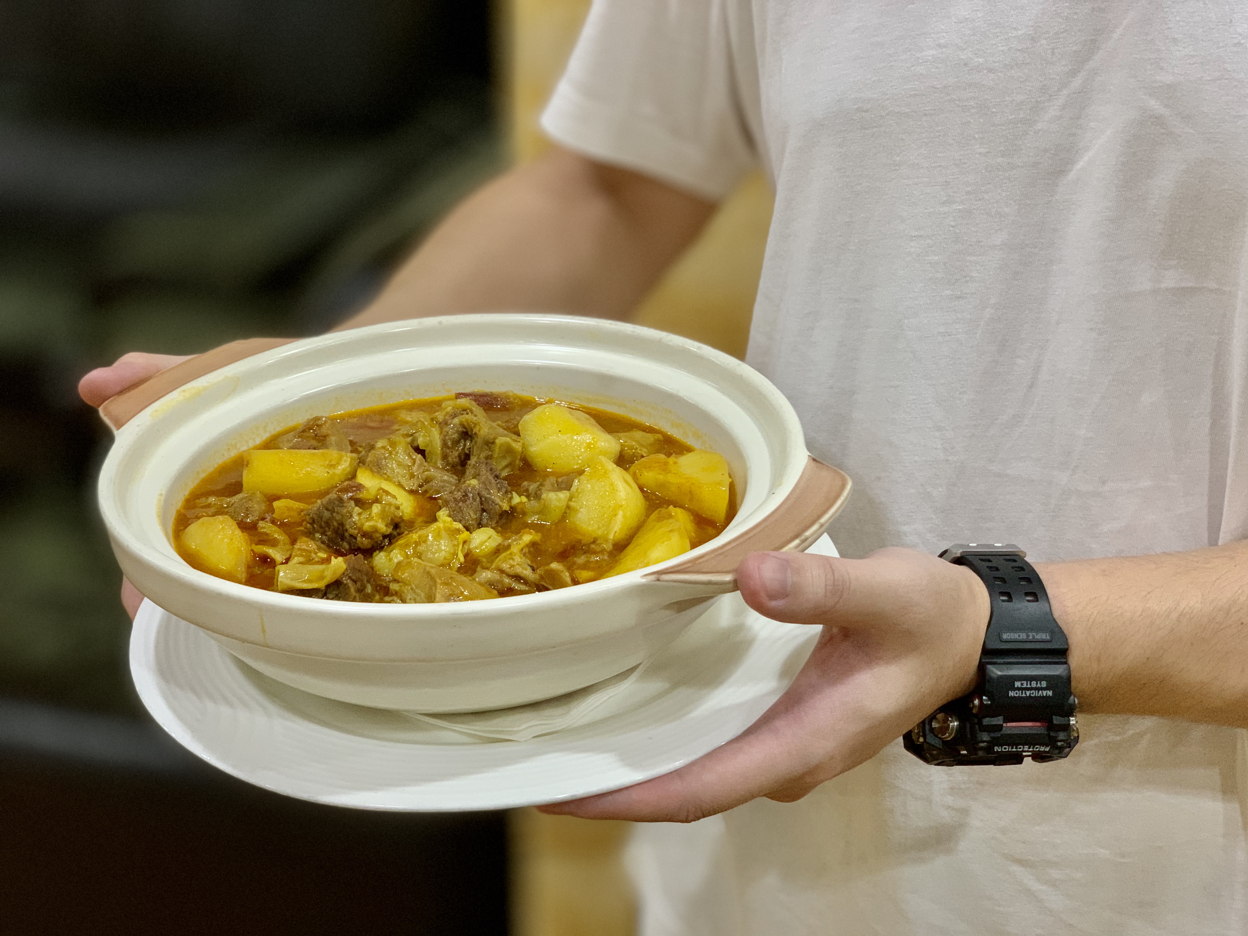 Julio Lei holding a pot of ox tail curry from APOMAC Macau Lifestyle