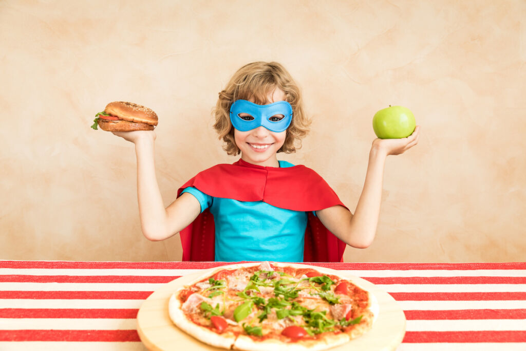 Superhero child eating superfood