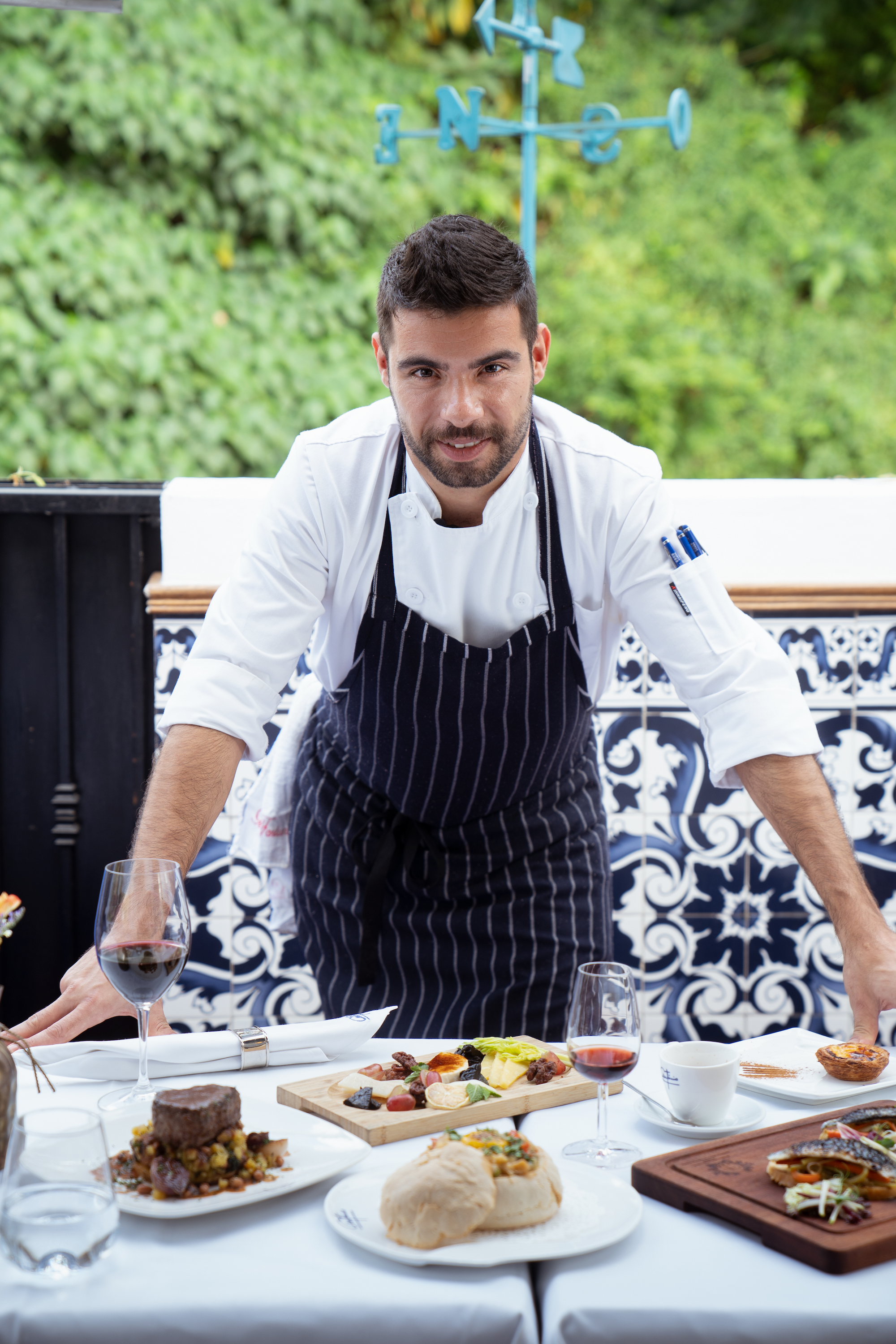 Chef David Abreu from Antonio Looking at the Camera with Food on the Table