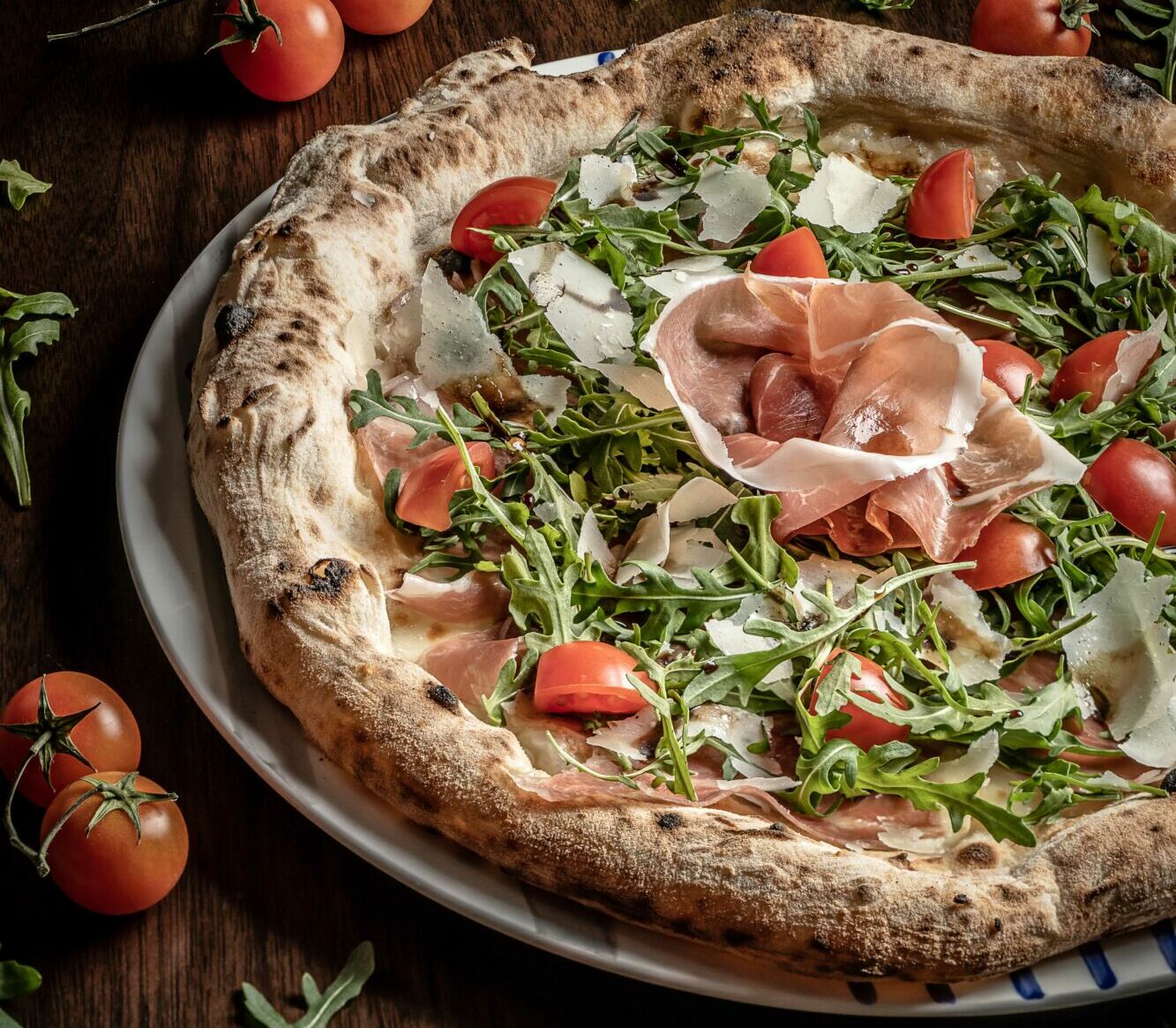 Pizza Ricca_(Pizza with mozzarella, Parma ham, arugula, cherry tomatoes, parmesan flake and balsamic vinegar)